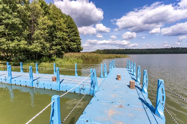 Muelle de plástico de color en la orilla de un gran lago — Foto de Stock