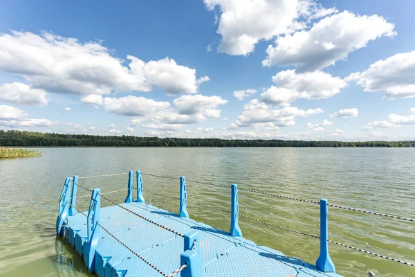 Muelle de plástico de color en la orilla de un gran lago — Foto de Stock