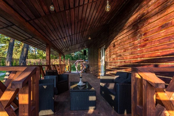 interior of empty hall veranda in wooden village vacation home with vintage lamps and chairs