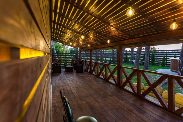 Интерьер пустой веранды зала в деревянном деревенском доме отдыха с винтажными лампами и стульями — стоковое фото