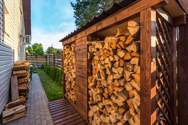 Cosecha de leña para el invierno cerca de casa de vacaciones pueblo de madera — Foto de Stock