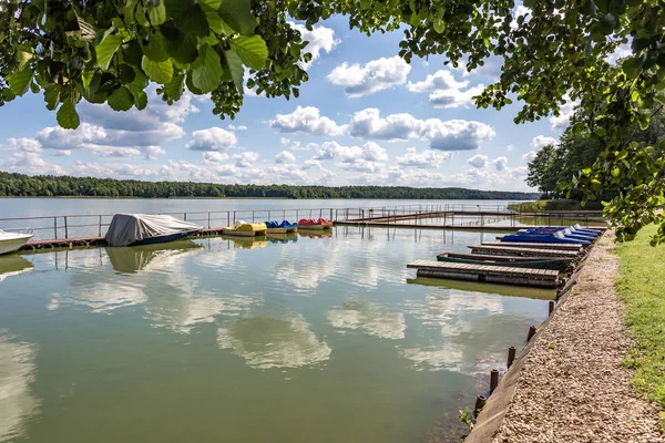 Muelle en la orilla de un gran lago en el día de verano con hermosa c — Foto de Stock