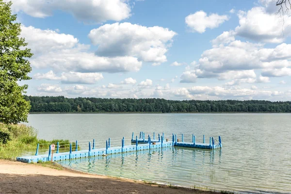 Muelle de plástico de color en la orilla de un gran lago — Foto de Stock