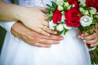 damat düğün kırmızı beyaz gül buketi ile gelin kucaklar. yeni evli çiftin elinde yüzük