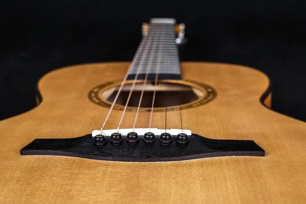 Trä konsistens av nedre däck sex strängar akustisk gitarr på svart bakgrund. gitarr form — Stockfoto