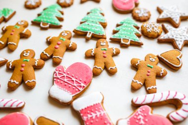 Yıldız şeklinde el yapımı şenlikli zencefilli kurabiye, kar taneleri, insanlar, çorap, personel, eldivenler, Noel ağaçları, xmas ve beyaz kağıt arka plan üzerinde yeni yıl tatili için kalpler