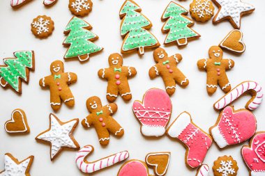 Yıldız şeklinde el yapımı şenlikli zencefilli kurabiye, kar taneleri, insanlar, çorap, personel, eldivenler, Noel ağaçları, xmas ve beyaz kağıt arka plan üzerinde yeni yıl tatili için kalpler