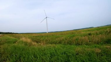 mavi gökyüzü arka plan üzerinde alanında bir yel değirmeni pervane dönen bıçakları. Rüzgar enerjisi üretimi. Saf yeşil enerji.