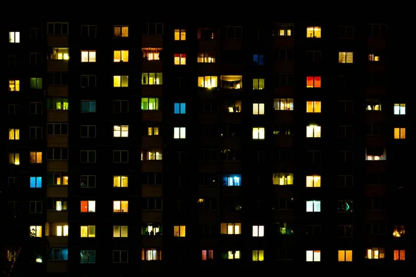 고층 건물의 창문에는 다 문화의 빛으로 이루어진 평평 한 야간 전경이 펼쳐져 있다. 큰 도시에서의 삶 — 스톡 사진