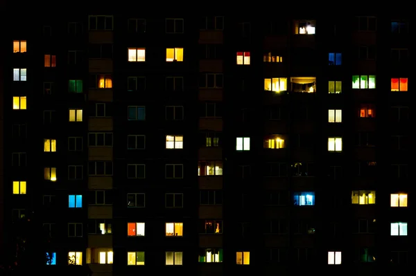 Panorama nocturne plat de lumière multicolore dans les fenêtres de bâtiments à étages multiples. vie dans la grande ville — Photo