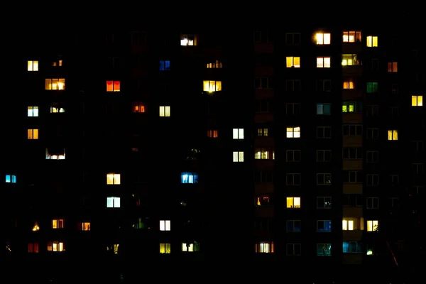 Panorama nocturne plat de lumière multicolore dans les fenêtres de bâtiments à étages multiples. vie dans la grande ville — Photo