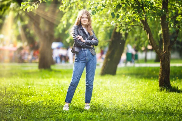 Retrato de niña hermosa y elegante en el parque de la ciudad en el fondo verde del bosque — Foto de Stock