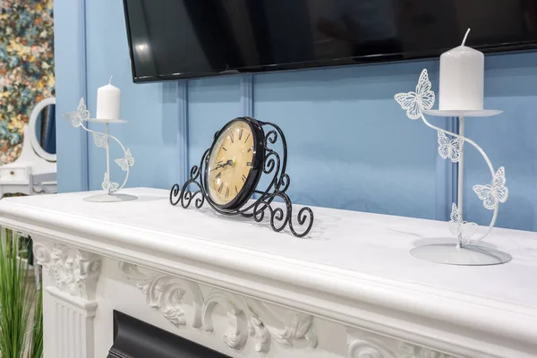 Old vintage clock on a fireplace shelf in a rich interior with a — ストック写真