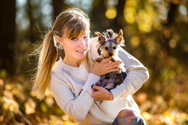 Kız sonbahar ormanında yerde oturur ve rahatlar ve oynar.