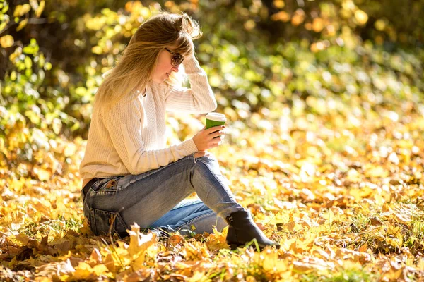 Meisje zit en ontspannen op de grond in de herfst bos met coff — Stockfoto