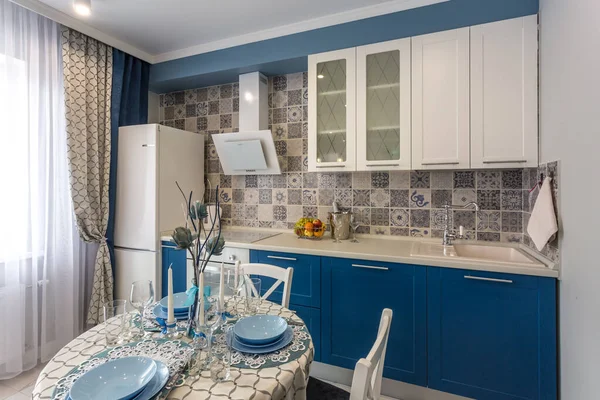 MINSK, BELARUS - SEPTIEMBRE, 2019: Interior de la moderna cocina de lujo con mesa de invitados en apartamentos tipo estudio en estilo minimalista con color azul — Foto de Stock