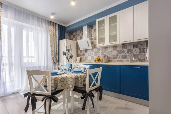 MINSK, BELARUS - SEPTIEMBRE, 2019: Interior de la moderna cocina de lujo con mesa de invitados en apartamentos tipo estudio en estilo minimalista con color azul — Foto de Stock