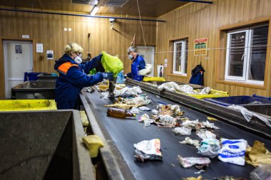 Grodno, Belarus - 16 Ekim 2017: Ayrı çöp toplama. Daha fazla atık için geri dönüşüm ve depolama. İşçiler modern bir atık geri dönüşüm fabrikasında işlenmek üzere atık tasnif materyali atıyorlar