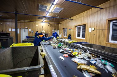 Grodno, Belarus - 16 Ekim 2017: Ayrı çöp toplama. Daha fazla atık için geri dönüşüm ve depolama. İşçiler modern bir atık geri dönüşüm fabrikasında işlenmek üzere atık tasnif materyali atıyorlar