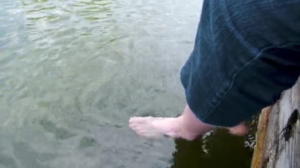 Man Lange Broek Bungelt Zijn Benen Het Water Van Het — Stockvideo