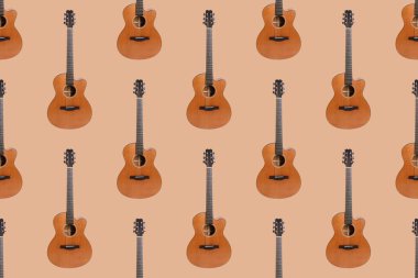 Turuncu arkaplanda altı telli akustik gitarın kusursuz ahşap dokusu.
