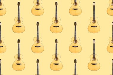 Sarı arkaplanda altı telli akustik gitarın kusursuz ahşap dokusu.