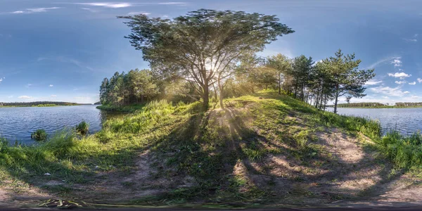 full seamless spherical hdri panorama 360 degrees angle view near huge tree on banks of wide river with rays of sun through branches  in equirectangular projection, ready VR AR virtual reality content