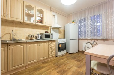MINSK, BELARUS - 2020 AĞUSTOS: Stüdyo dairelerdeki açık renkli minimalist tarzda modern lüks mutfağın iç mimarisi