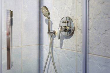 Pahalı tavan arası banyosunda musluk ve musluk var. Duş eklentisi olan bir köşedeki duş kabininin ayrıntıları