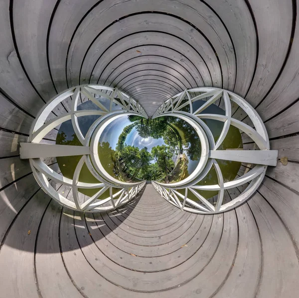 Abstract view of little planet transformation of spherical panorama 360 degrees. Spherical abstract aerial view on wooden bridge. Curvature of space.