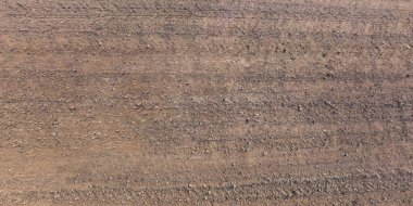 Araba lastiği izleri olan çakıl yolu yüzeyinden görüntü