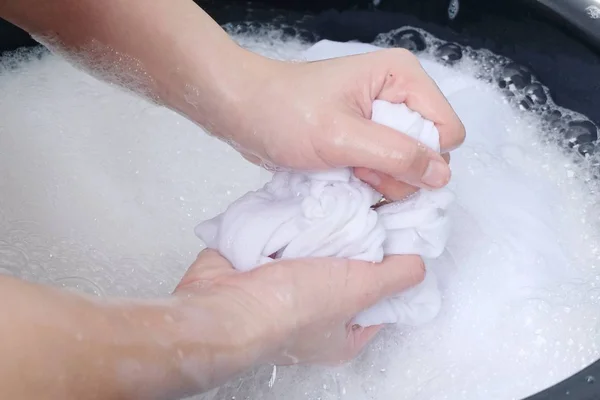 一个女人在肥皂水中用手洗衣服 在白色的背景上被隔离 — 图库照片
