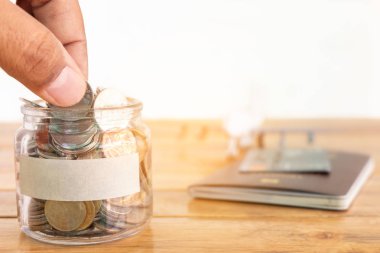 Para tasarruf kavramı. Sizin kavramı için para kavanoza para topluyor. Holding sikke, sikke, uçak oyuncak ve pasaport ile para kavanoz el