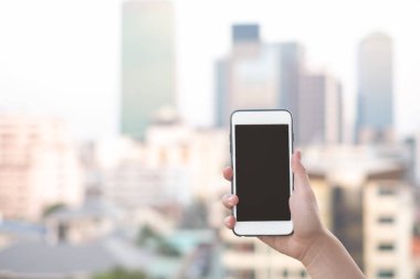 akıllı telefon veya cep telefonu arka plan ve kopya alanı bina şehir ile tutan el