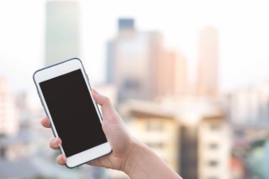 akıllı telefon veya cep telefonu arka plan ve kopya alanı bina şehir ile tutan el
