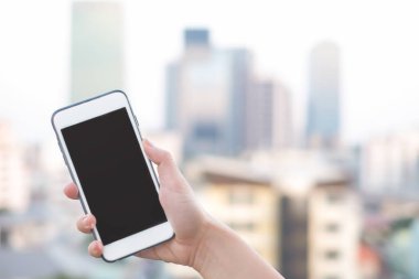 akıllı telefon veya cep telefonu arka plan ve kopya alanı bina şehir ile tutan el