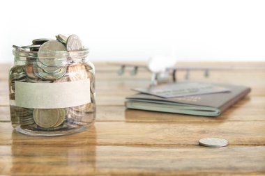 Para tasarruf kavramı. Sizin kavramı için para kavanoza para topluyor. Para kavanozu paralar, uçak oyuncak ve pasaport ile