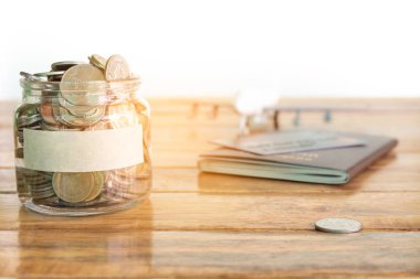 Para tasarruf kavramı. Sizin kavramı için para kavanoza para topluyor. Para kavanozu paralar, uçak oyuncak ve pasaport ile