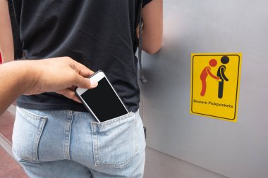 Geri olan bir kadın cep mobil telefon çalmak hırsız yankesici işareti sembol arka plan dikkat edin.