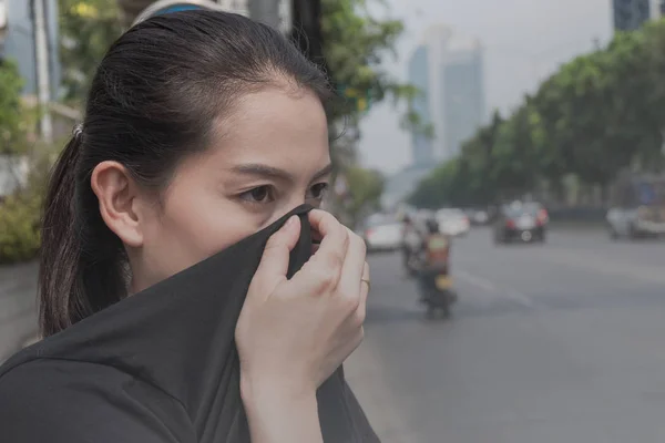 女性は悪い交通公害のため手で自分の鼻を閉じます ロイヤリティフリーのストック画像
