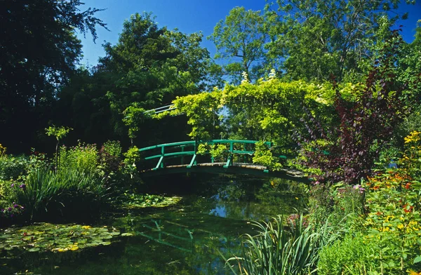 庭とノルマンディー フランス ジヴェルニーのクロード モネの睡蓮の池に架かる日本橋 可能性があります 藤早春の睡蓮の池に成長している象徴的な日本橋 — ストック写真