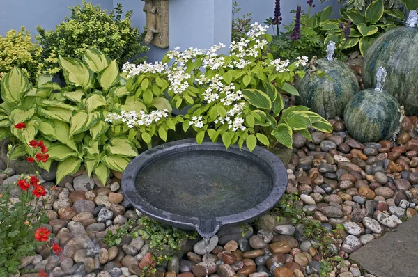 A detail of a small courtyard garden with pottery water features