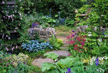A cottage garden with mixed planting and a drystone wall clipart