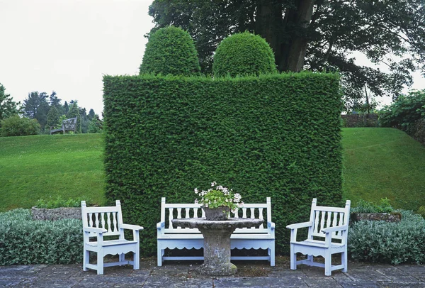 一个国家南草坪旁的露台上的装饰花园座椅 — 图库照片