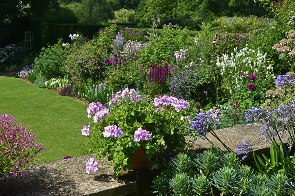 Vue sur le jardin de la terrasse à la frontière colorée et campagne ouverte — Photo