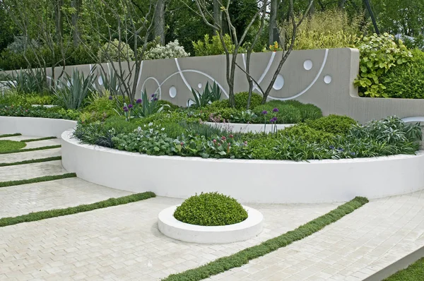 Moderno jardín con camas elevadas y un diseño decorativo de pared — Foto de Stock