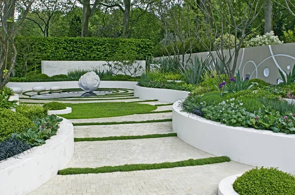 Μοντέρνος κήπος με γλυπτά χαρακτηριστικά και υπερυψωμένα κρεβάτια — Φωτογραφία Αρχείου