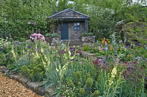 Une maison de campagne et un jardin situés dans une rocaille boisée — Photo