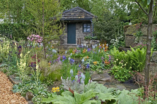 Egy vidéki kunyhó és kert található, egy erdős sziklakert — Stock Fotó
