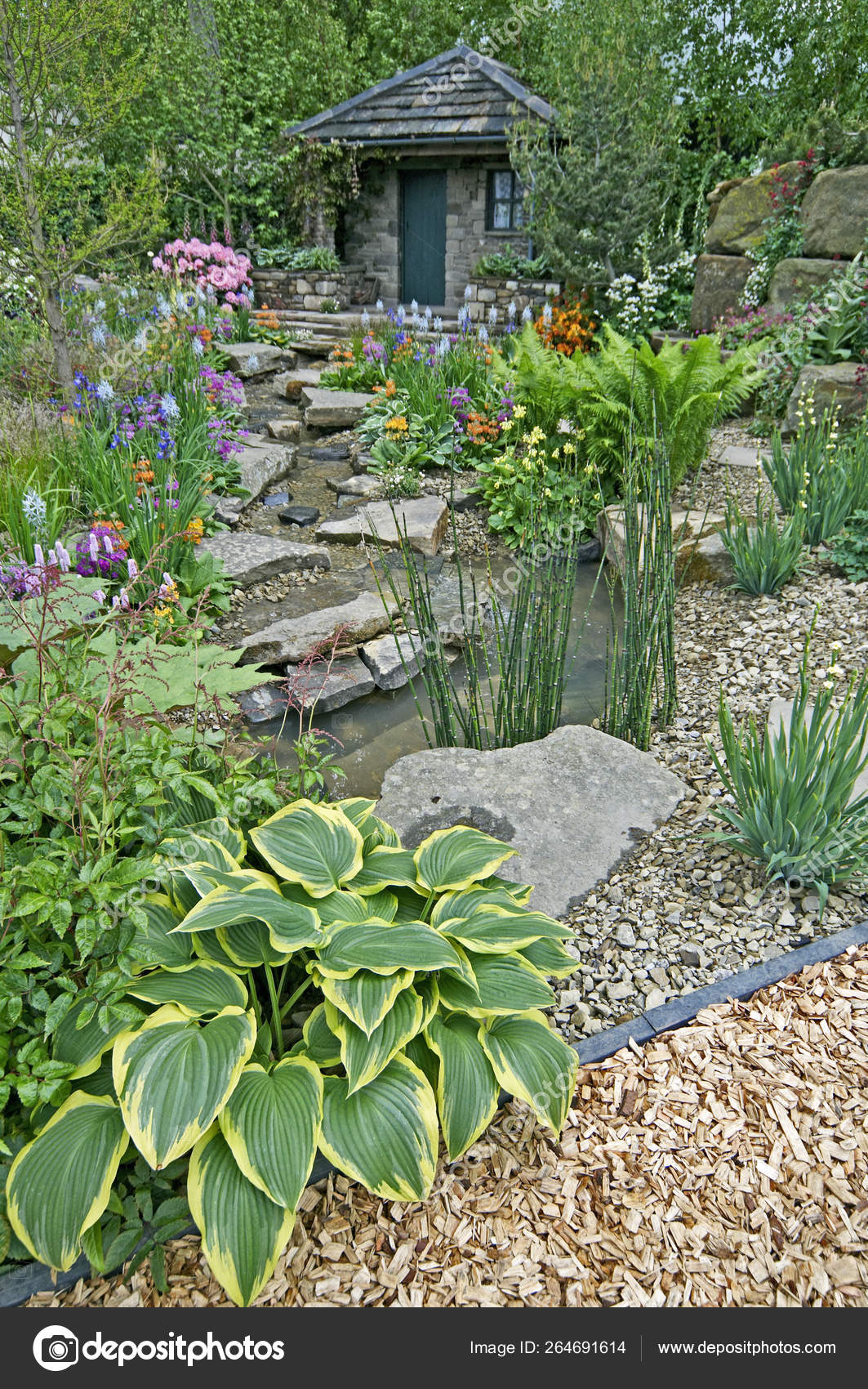 A Country Cottage Garden In A Wooded Rockery With Colourful